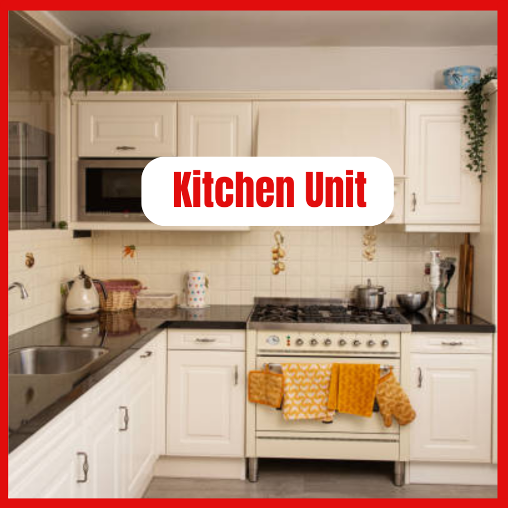 Modern white fitted kitchen unit with shaker-style cabinets, integrated oven, gas hob, and dark worktops in a bright kitchen.