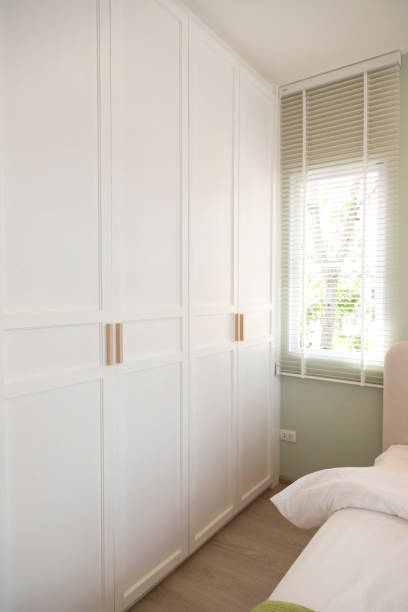 White wooden closet doors with wood handles in bedroom.