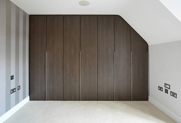 "a nicely designed and fitted wardrobe unit in the bedroom of a penthouse apartment. The doors are finished in walnut with long, slim brushed metal handles.Looking for a Wardrobe image Then please see my other Wardrobe and Walk-in Wardrobe related images by clicking on the Lightbox link below...A>A"