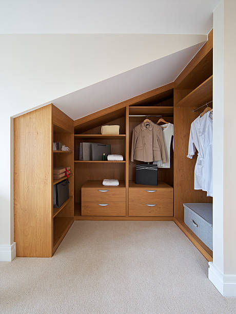 a wardrobe in a loft apartment (this is "hers" of two wardrobes in the bedroom), nicely fitted to make use of the available space and angles. Finished in oak, there is good space for hanging clothes together with drawers and shelves.